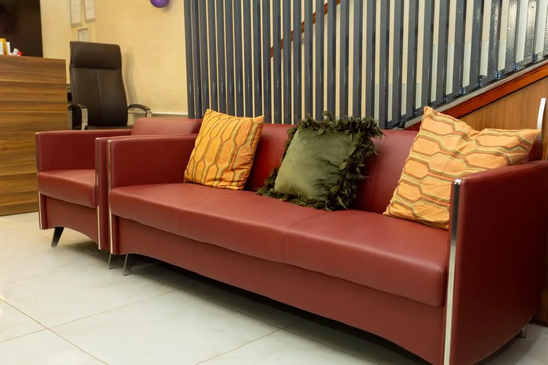 A seating area in the firm’s reception with a leather sofa and cushions.