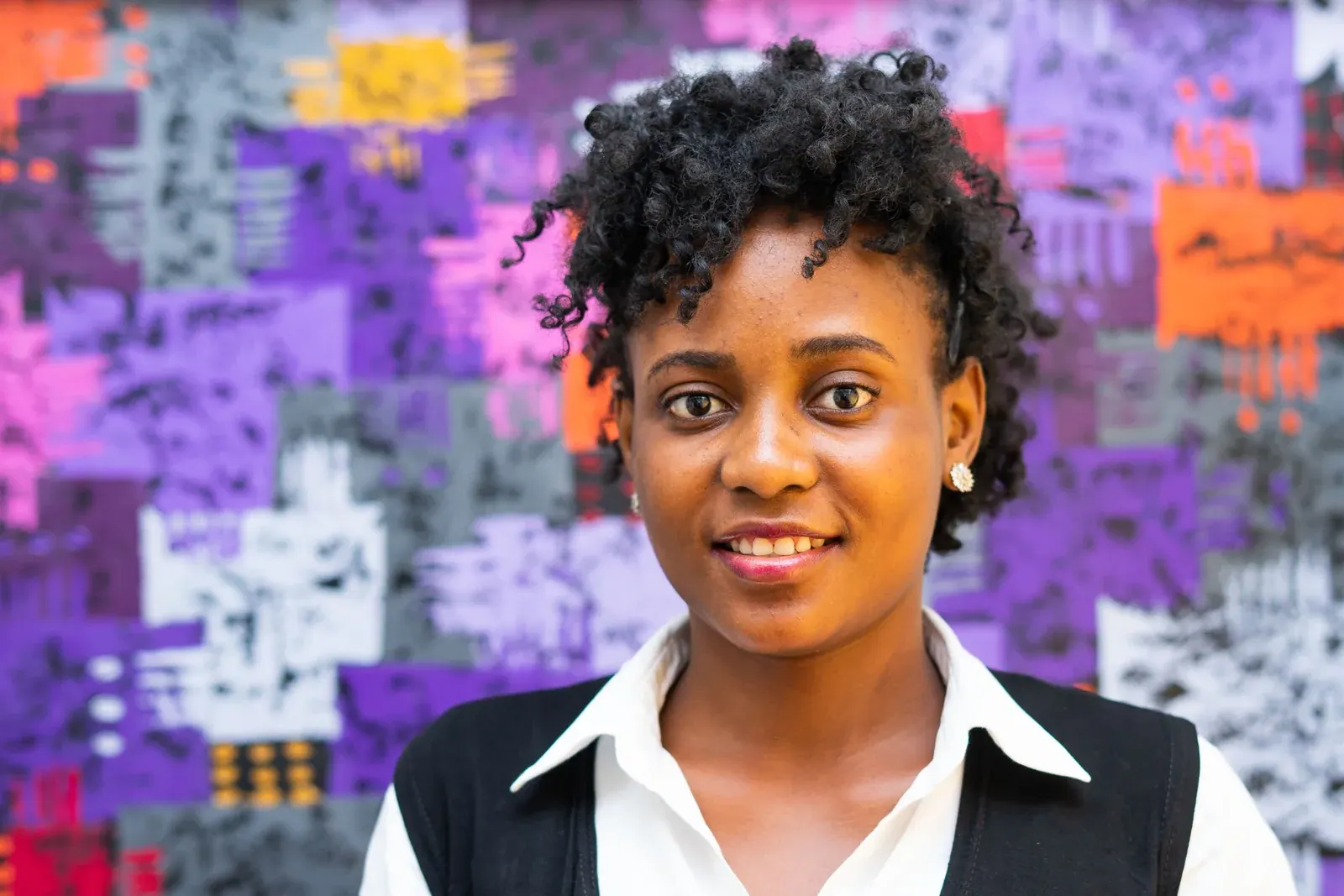 A young lawyer photographed against the firm’s purple artwork.